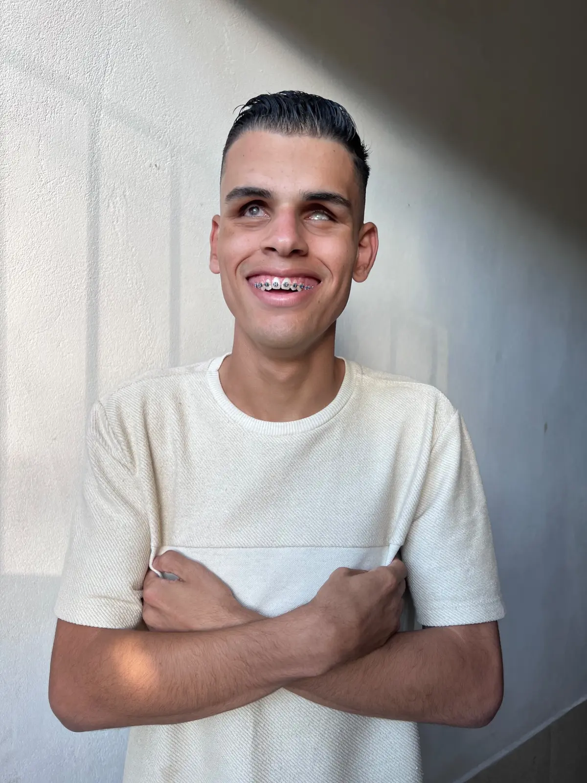 Enzo Arantes sorrindo em retrato com camiseta clara